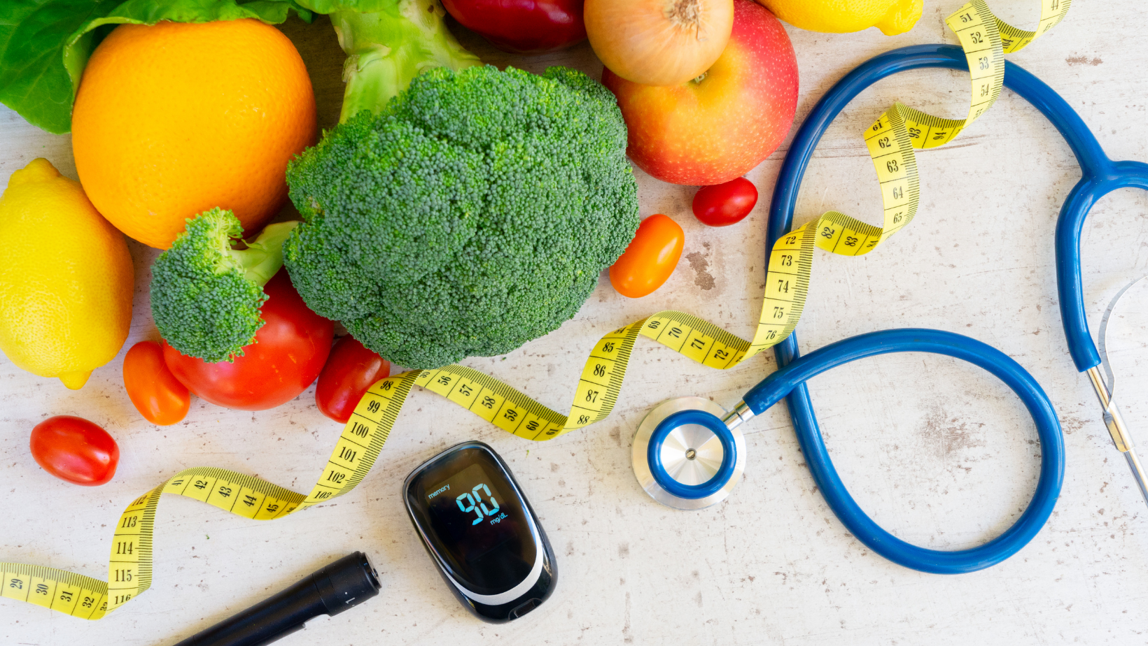 Brightly colored healthy vegetables with a stethoscope and blood sugar monitor